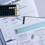 Flat lay of financial documents, tax checklist, and calculator for tax prep.