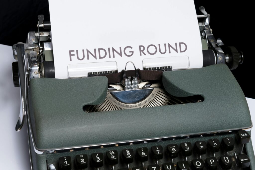 A vintage typewriter displaying the text 'Funding Round,' symbolizing investment and business planning.