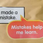 Bright square and speech bubble sign with motivational quotes about mistakes and learning.